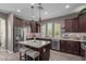 Modern kitchen with stainless steel appliances, granite countertops, and an island with bar stools at 20539 W Terrace Ln, Buckeye, AZ 85396