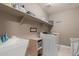 Bright laundry room with sink, shelving and new, white washer and dryer at 20539 W Terrace Ln, Buckeye, AZ 85396