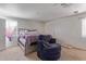 Comfortable bedroom with plush chair, neutral carpet, and a soft, inviting atmosphere at 207 E Cedar Ave, Casa Grande, AZ 85122