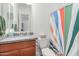 Well-lit bathroom features a vanity with granite counters and a decorative shower curtain at 21165 E Thornton Rd, Queen Creek, AZ 85142