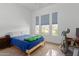 Bright bedroom with three large windows, carpeted floor, and a comfortable bed and desk at 21165 E Thornton Rd, Queen Creek, AZ 85142