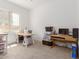 Bright bedroom area with crafting tables, window, and neutral carpet flooring at 21165 E Thornton Rd, Queen Creek, AZ 85142
