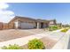 Inviting home exterior featuring a two-car garage, desert landscaping, and a covered front entrance at 21165 E Thornton Rd, Queen Creek, AZ 85142