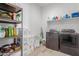 Functional laundry room with modern washer and dryer, shelving and tile flooring at 21165 E Thornton Rd, Queen Creek, AZ 85142