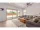 Bright living room featuring a large sectional sofa, tile flooring, ceiling fan, and sliding glass doors at 21165 E Thornton Rd, Queen Creek, AZ 85142