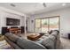 Comfortable living room with a large sectional sofa, and sliding glass doors to the backyard patio at 21165 E Thornton Rd, Queen Creek, AZ 85142
