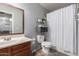 Bathroom with a wood vanity, framed mirror, tile flooring, and bath-tub with shower and curtain at 23830 W Chambers St, Buckeye, AZ 85326
