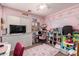 Bright bedroom featuring pink walls, white trim, and a cozy rug with a study area and organization at 23830 W Chambers St, Buckeye, AZ 85326