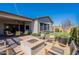 A serene backyard featuring a fire pit, an outdoor seating area, patio, green grass, and desert landscaping at 25751 S 227Th Way, Queen Creek, AZ 85142