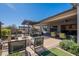 Backyard featuring a patio with outdoor kitchen, fire pit and seating areas, with brick pavers and lush landscaping at 25751 S 227Th Way, Queen Creek, AZ 85142