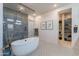 Luxurious bathroom featuring a standalone tub, glass-enclosed shower, and walk-in closet access at 25751 S 227Th Way, Queen Creek, AZ 85142