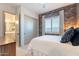 Comfortable bedroom features a decorative brick wall, closet, and ensuite bath at 25751 S 227Th Way, Queen Creek, AZ 85142