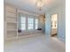 Bright bedroom featuring a window seat, modern light fixture, and an attached bathroom at 25751 S 227Th Way, Queen Creek, AZ 85142