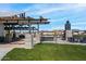 Community outdoor gathering space with shaded seating areas, modern architectural details, and well-maintained green lawns at 25751 S 227Th Way, Queen Creek, AZ 85142