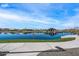 Scenic lake view showcasing community amenities, including a covered pavilion, with clear blue skies reflected in the water at 25751 S 227Th Way, Queen Creek, AZ 85142