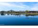 Picturesque lake view with a decorative water tower reflecting on the surface and mountains in the background at 25751 S 227Th Way, Queen Creek, AZ 85142