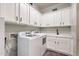 Well-organized laundry room with white cabinets, modern appliances, and ample counter space for folding at 25751 S 227Th Way, Queen Creek, AZ 85142