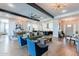 Open concept living room with wooden beams, modern lighting, and access to the dining and kitchen area at 25751 S 227Th Way, Queen Creek, AZ 85142
