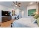 Spacious main bedroom with wood flooring, ceiling fan, exercise bike, and en suite bathroom entrance at 25751 S 227Th Way, Queen Creek, AZ 85142