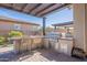 Outdoor kitchen featuring a stainless steel grill, bar seating, and a wood pergola cover with brick pavers at 25751 S 227Th Way, Queen Creek, AZ 85142