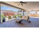 Spacious covered patio featuring comfortable seating, ceiling fans, and a rustic wood coffee table with brick pavers at 25751 S 227Th Way, Queen Creek, AZ 85142