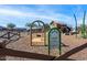 Close-up of community playground featuring swings, slides, and climbing equipment, surrounded by a protective wooden fence at 25751 S 227Th Way, Queen Creek, AZ 85142