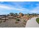 Community playground featuring a climbing structure, slides, and swings, surrounded by desert landscaping and a secure wooden fence at 25751 S 227Th Way, Queen Creek, AZ 85142