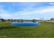 Scenic community pond with lush green grass and neighborhood amenities on a sunny day at 25751 S 227Th Way, Queen Creek, AZ 85142