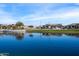 Picturesque water view featuring tranquil lake reflecting nearby homes and lush green landscapes under a bright blue sky at 25751 S 227Th Way, Queen Creek, AZ 85142