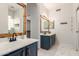 Bright bathroom with double sink, wood frame mirrors, and modern fixtures over marble floors at 3019 E Redfield Rd, Phoenix, AZ 85032
