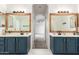 Bathroom featuring double sinks with wood frame mirrors, and marble tile floor at 3019 E Redfield Rd, Phoenix, AZ 85032