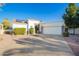 Attractive front of home with driveway, desert landscaping, lawn, and two car garage at 3019 E Redfield Rd, Phoenix, AZ 85032