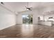 Large living room with a ceiling fan, wood-look flooring, and open access to the kitchen at 3019 E Redfield Rd, Phoenix, AZ 85032