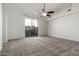 Large bedroom with a ceiling fan, neutral carpet and a sliding glass door to a private patio at 3019 E Redfield Rd, Phoenix, AZ 85032