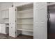 Walk-in pantry with ample shelving, located in a kitchen area with stainless steel refrigerator at 3019 E Redfield Rd, Phoenix, AZ 85032