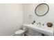 Stylish powder room featuring a pedestal sink, round mirror, and modern fixtures at 3019 E Redfield Rd, Phoenix, AZ 85032