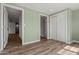 Light-filled bedroom showcasing wood-look flooring, closet, and fresh, light green paint at 3104 E Broadway Rd -- # 287, Mesa, AZ 85204