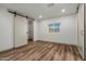 Cozy bedroom features wood-look flooring, a sliding barn door closet, and natural light at 3104 E Broadway Rd -- # 287, Mesa, AZ 85204