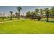 Picturesque community landscape with lush green grass, a tranquil pond, and a charming bridge at 3104 E Broadway Rd -- # 287, Mesa, AZ 85204