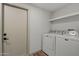 Functional laundry room with modern washer and dryer, and overhead shelving for convenience at 3104 E Broadway Rd -- # 287, Mesa, AZ 85204