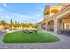 Expansive patio area includes a fire pit, ample seating, and lush green lawn, perfect for entertaining at 3446 E Knoll St, Mesa, AZ 85213