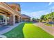 Lush backyard features well-maintained lawn, stone patios, an outdoor kitchen, and a tranquil waterfall pool at 3446 E Knoll St, Mesa, AZ 85213