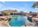 A tranquil pool featuring a rock waterfall and lush landscaping, creating an elegant outdoor space at 3446 E Knoll St, Mesa, AZ 85213