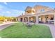 A well manicured yard with patio, seating area, outdoor games, and covered seating with fans at 3446 E Knoll St, Mesa, AZ 85213