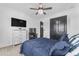 Bedroom with a ceiling fan, large dresser, television, and a closet at 3446 E Knoll St, Mesa, AZ 85213
