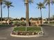 Entrance to the community with lush palm trees, flowers, and manicured landscaping at 3446 E Knoll St, Mesa, AZ 85213