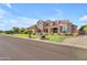 Stunning two-story home featuring stone and stucco accents, professionally landscaped lawn, and porte-cochère at 3446 E Knoll St, Mesa, AZ 85213
