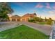 Spacious four-car garage with a brick driveway, surrounded by lush landscaping and well-maintained greenery at 3446 E Knoll St, Mesa, AZ 85213