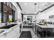 Bright kitchen features a marble island, white cabinetry, stainless steel appliances, and black and white patterned tile floors at 3446 E Knoll St, Mesa, AZ 85213