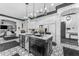 This kitchen features a black island with marble countertops, stainless steel appliances and black and white patterned floors at 3446 E Knoll St, Mesa, AZ 85213